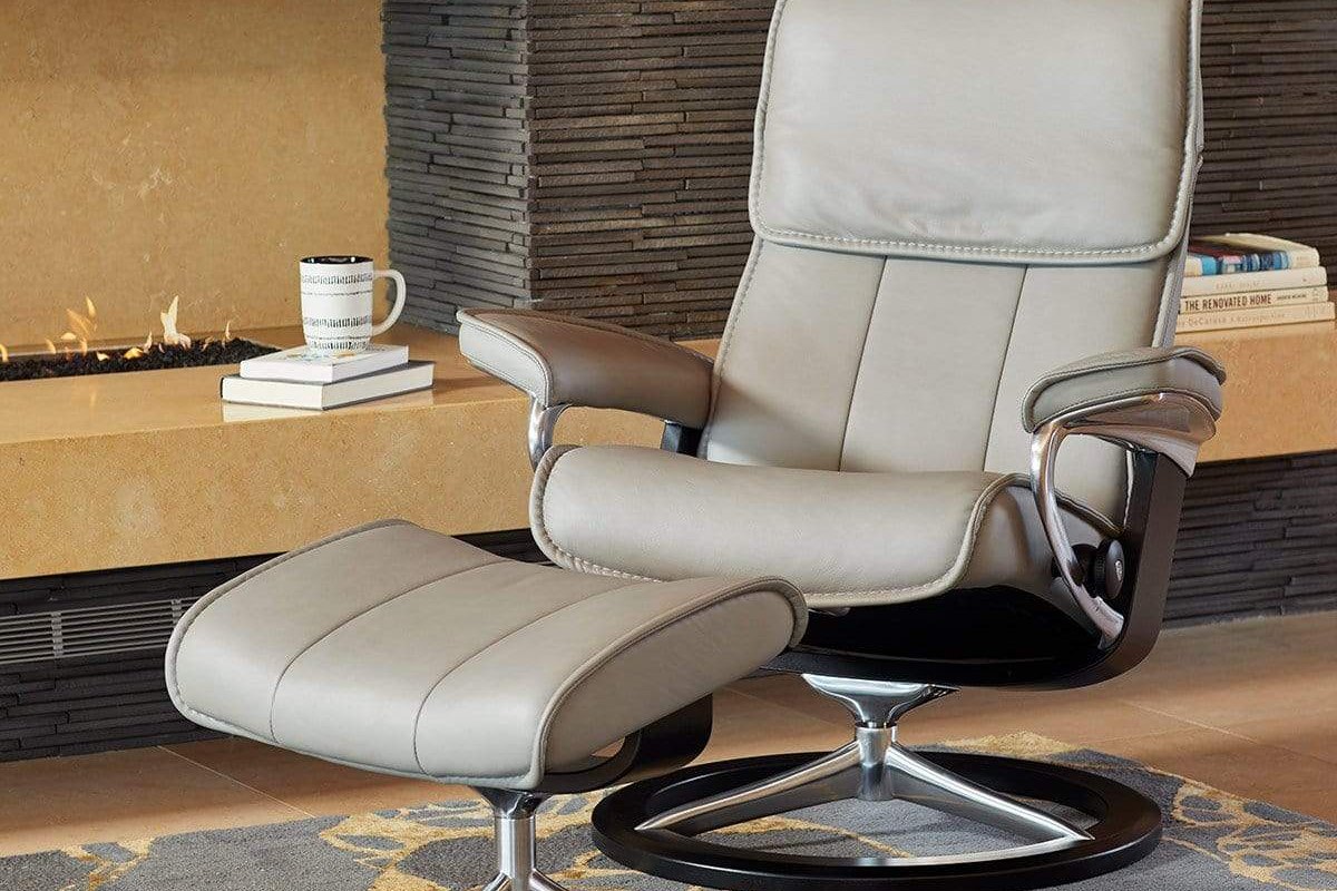 Stressless Admiral Signature recliner and ottoman in silver grey leather by a fireplace