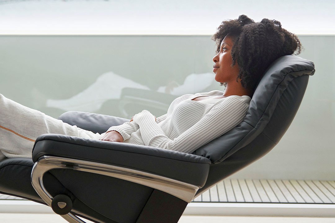 Woman reclining in a Stressless Mayfair recliner with Cross base in Paloma Shadow Blue