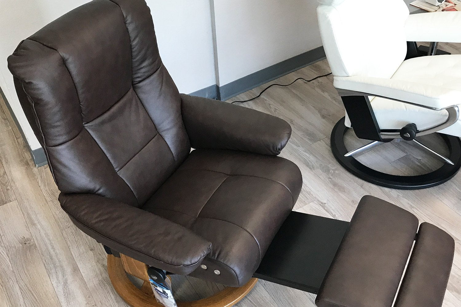 Close-up of a Stressless Mayfair recliner in chocolate leather with the LegComfort footrest extended