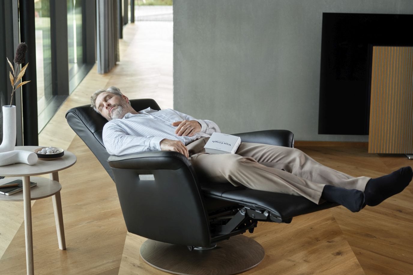 Man reclining with his feet up in a black leather Stressless Mike power recliner