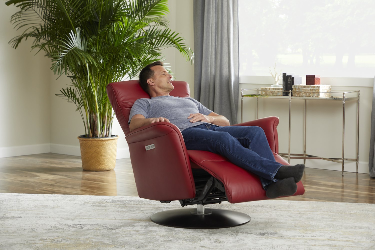 Man relaxing in a Stressless Mike power recliner in Paloma Cherry leather