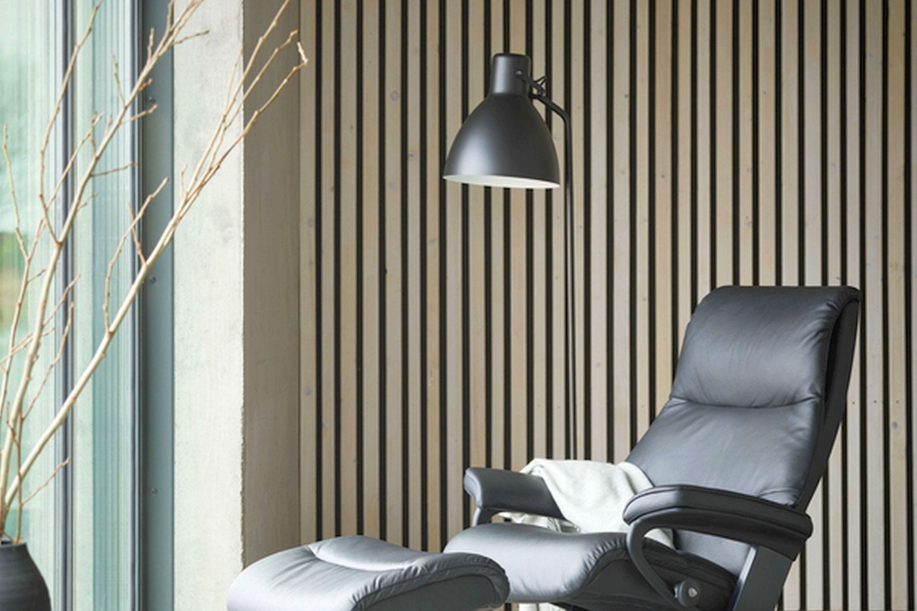 Stressless View recliner with Cross base and ottoman in black leather in a modern room