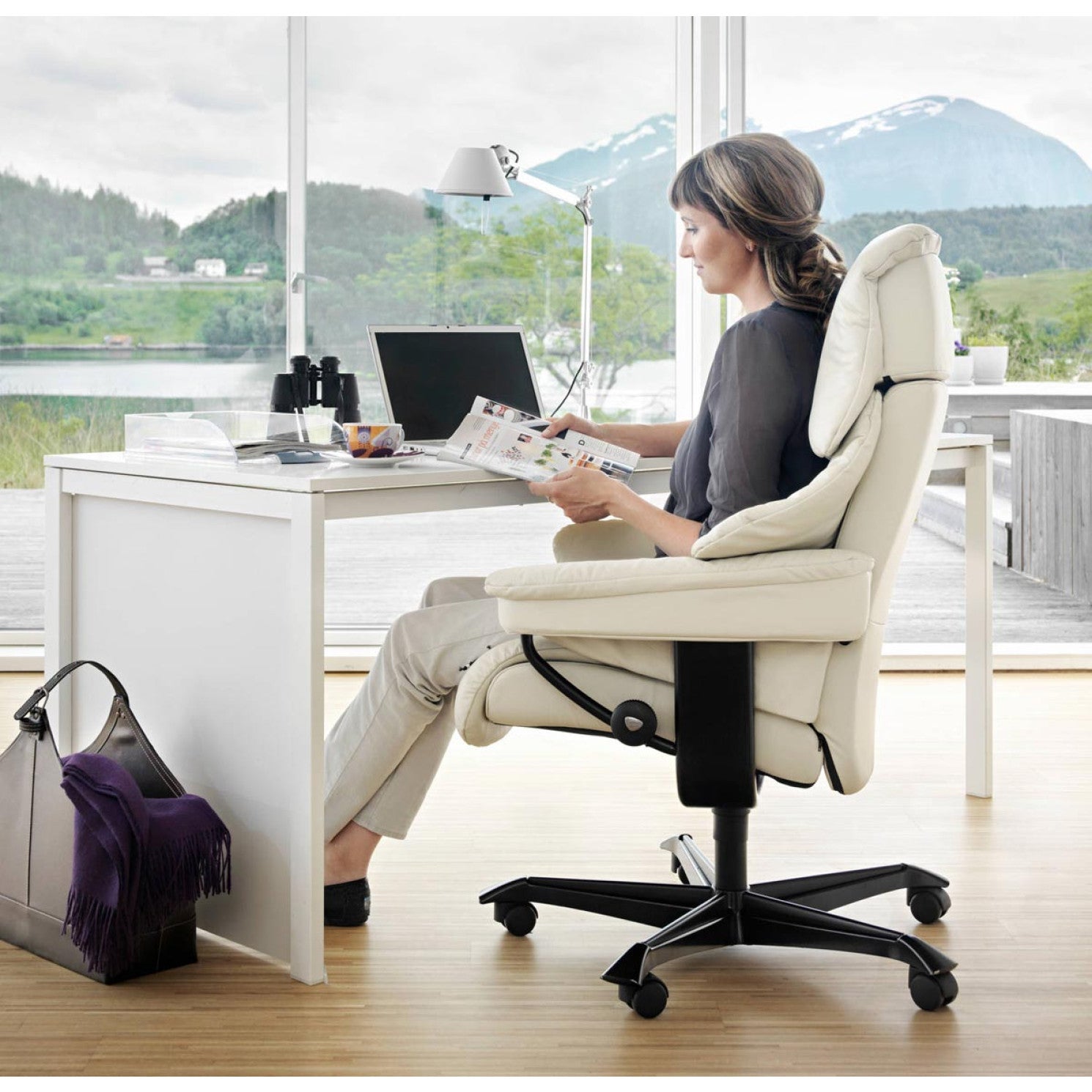 Stressless Reno home office chair in cream leather in a bright home office with mountain view