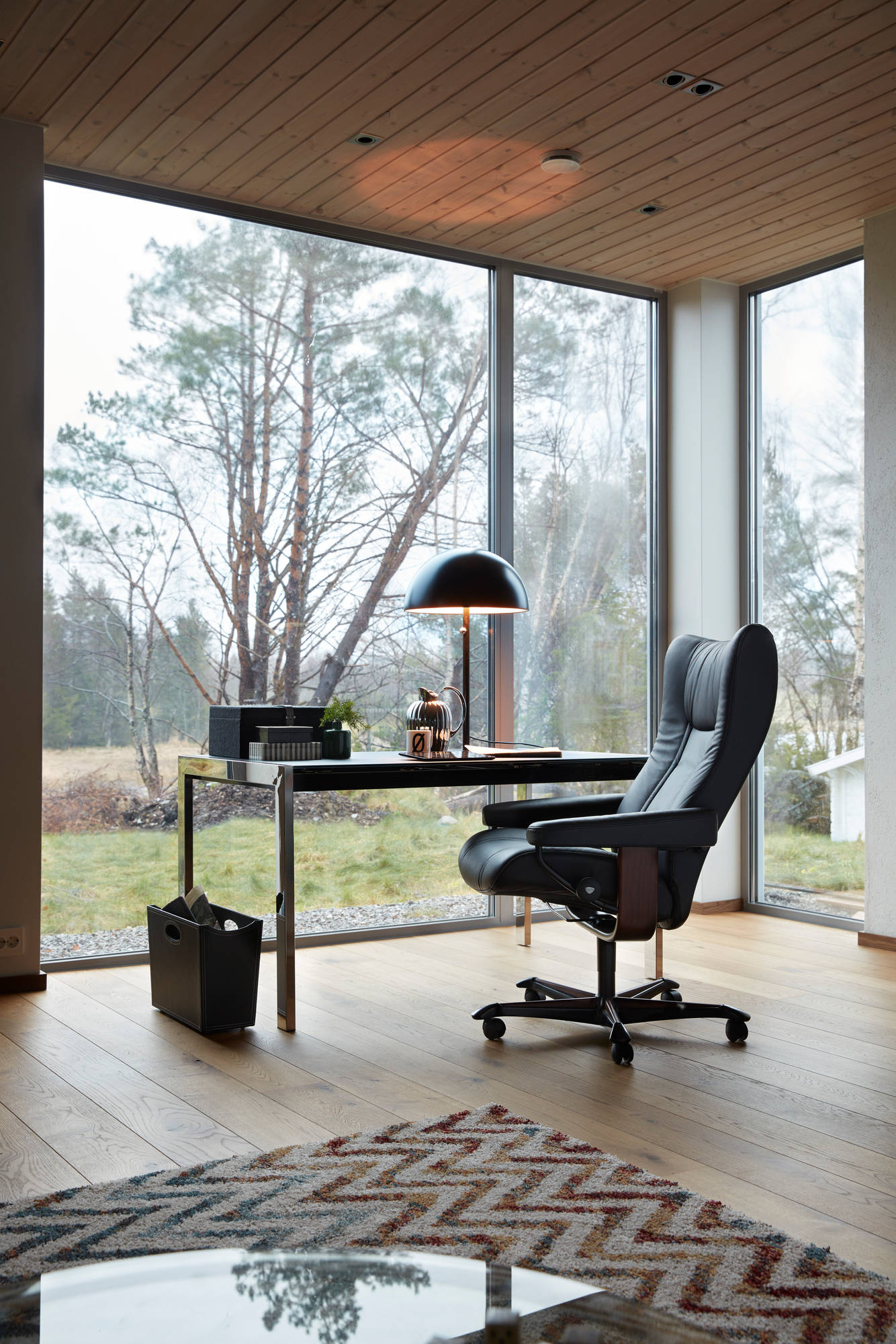 Stressless Wing home office chair in Paloma Black leather in a modern glass-walled office