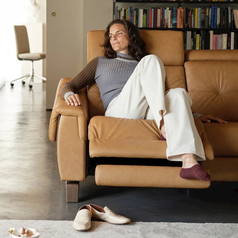 Model reclining in the Stressless® Anna Loveseat with A3 arms and footrest raised