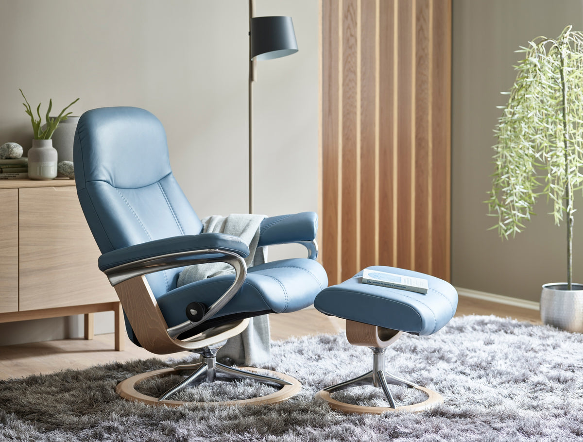 The Stressless Consul Small Signature recliner in Paloma Sparrow Blue leather with Oak wood.
